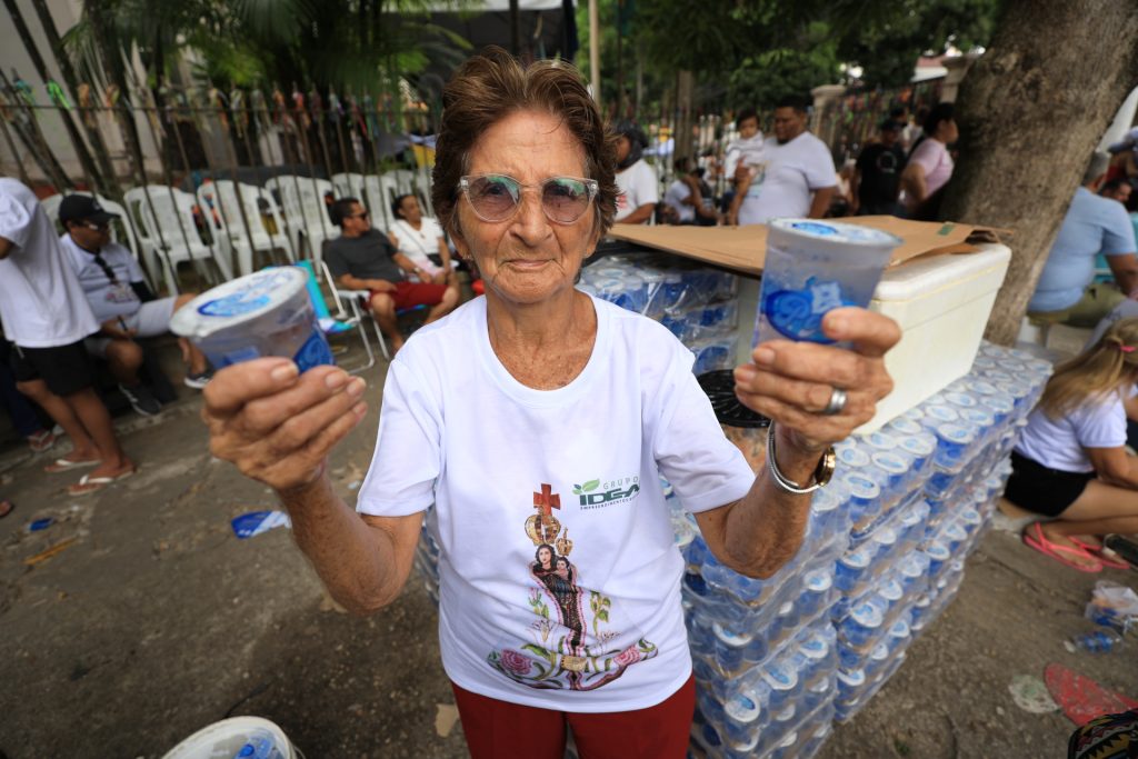 Julieta Ciabra dos Santos, 81 anos, distribui água aos romeiros, pagando promessa em agradecimento a uma graça alcançada